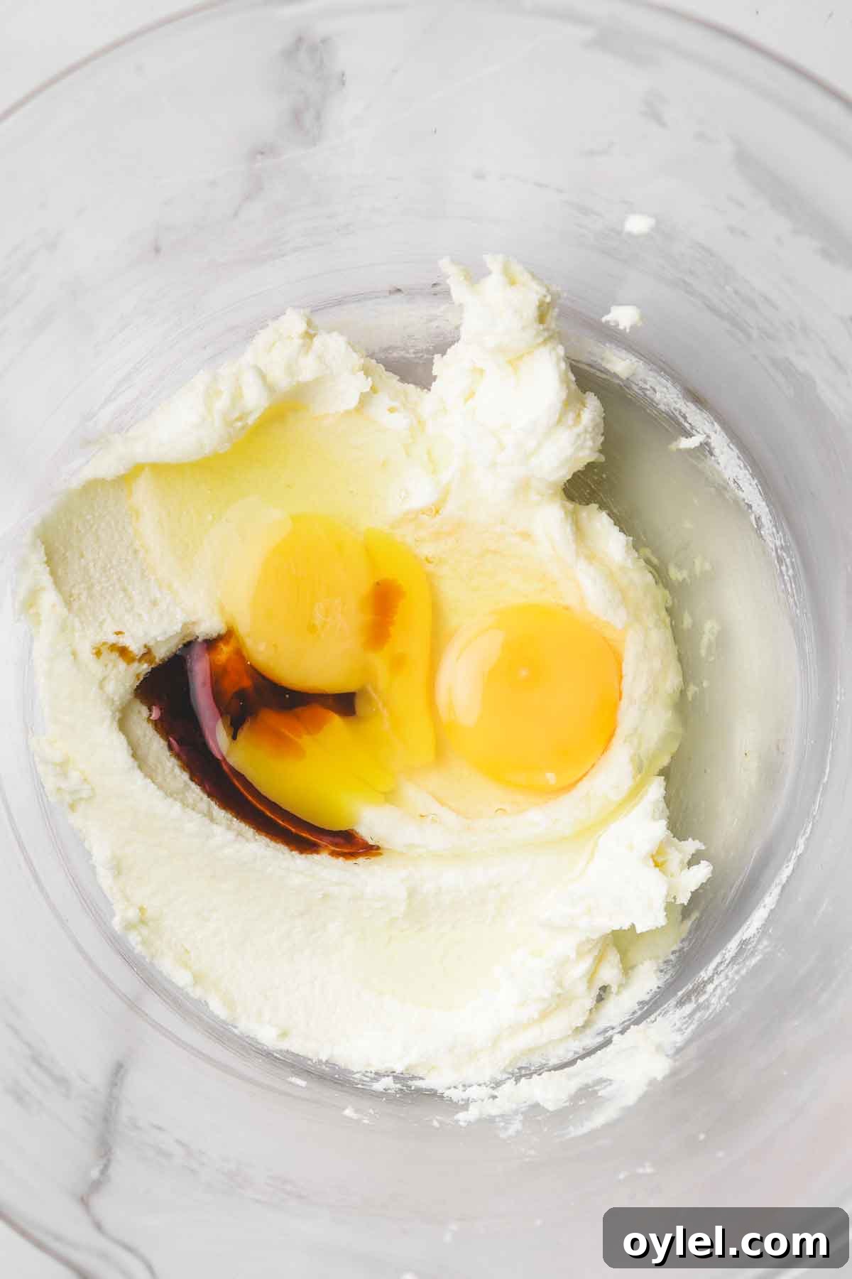 mixing vanilla cupcake batter with eggs butter and vanilla in a bowl