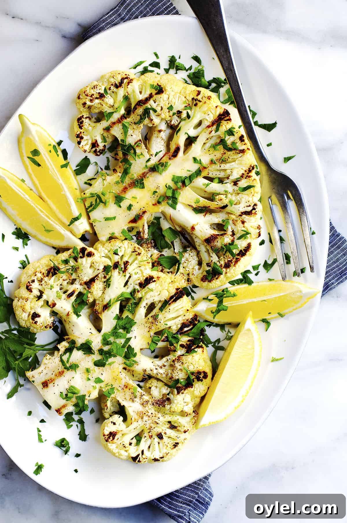 Grilled Cauliflower Steaks on a white oval platter