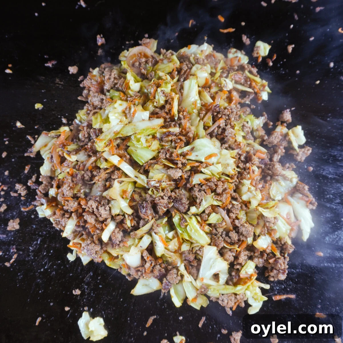 Ground Beef Egg Roll Bowl Recipe 6 beef egg roll bowl ingredients mixed together on griddle.