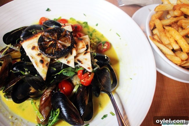 white bowl with mussels and side of fries at Canoe restaurant in victoria BC Canada.