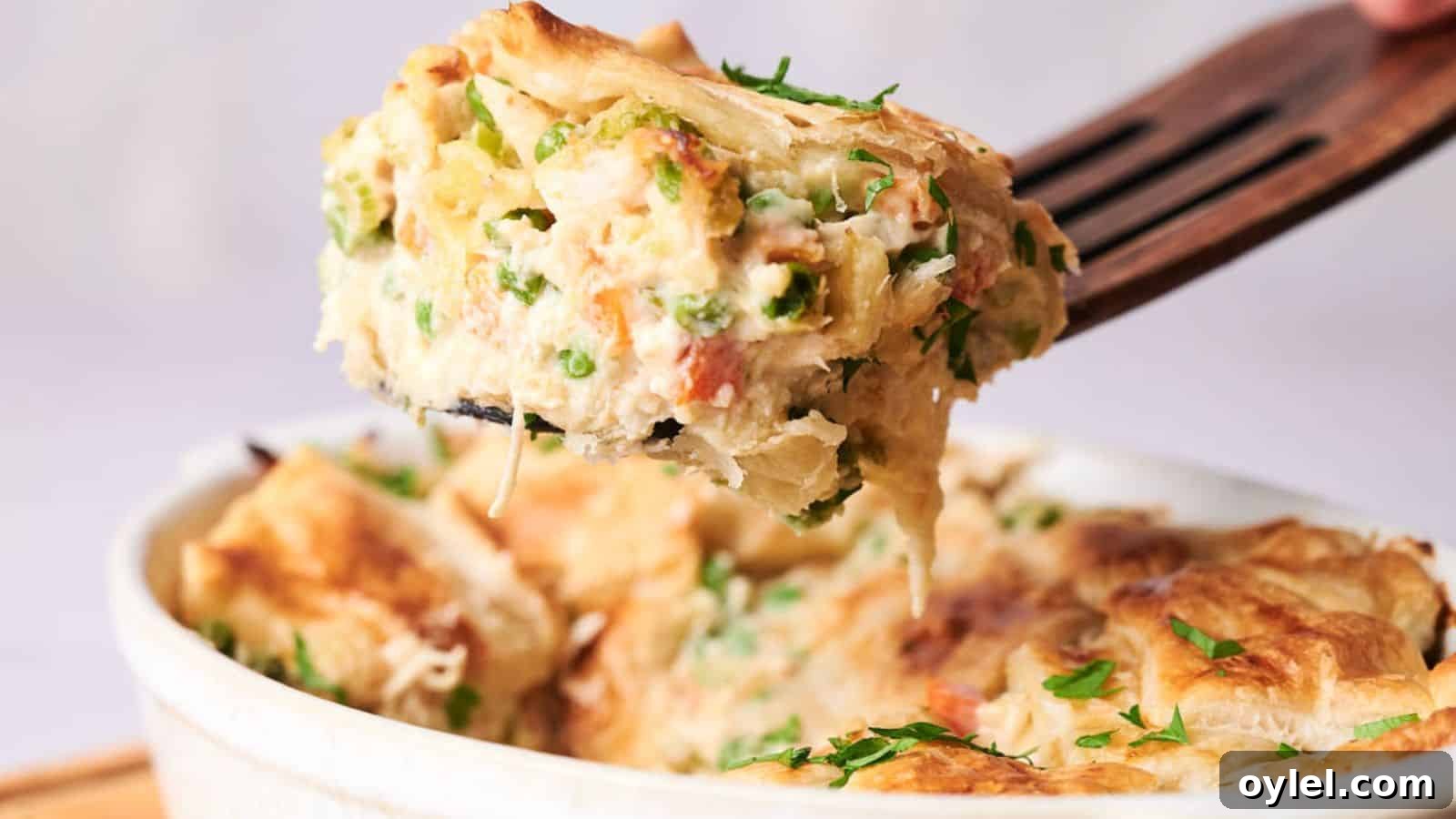 35 Chicken Breast Recipes to Simplify Weeknight Dinners 33 A serving of creamy chicken pot pie casserole with vegetables, lifted on a fork, with a flaky crust and garnished with herbs.