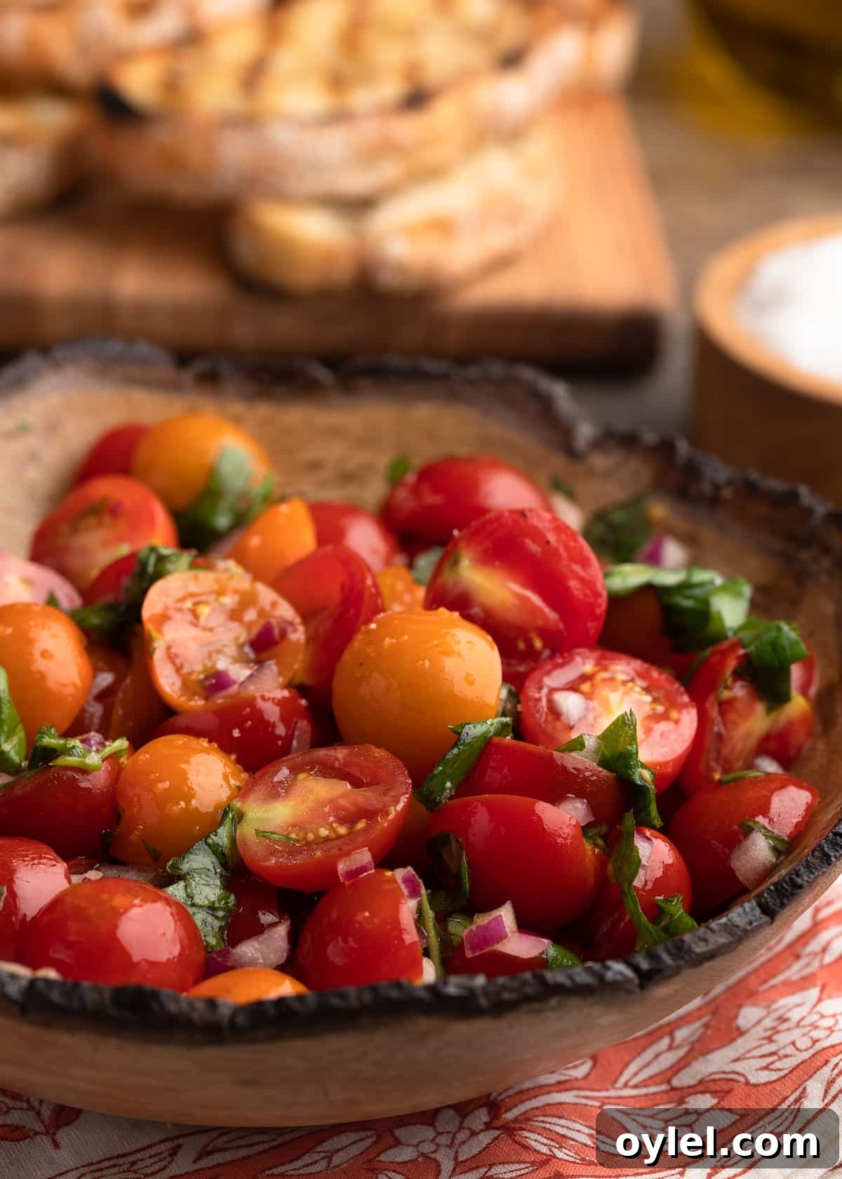 closeup of a wood bowl of cherry tomato bruschetta topping