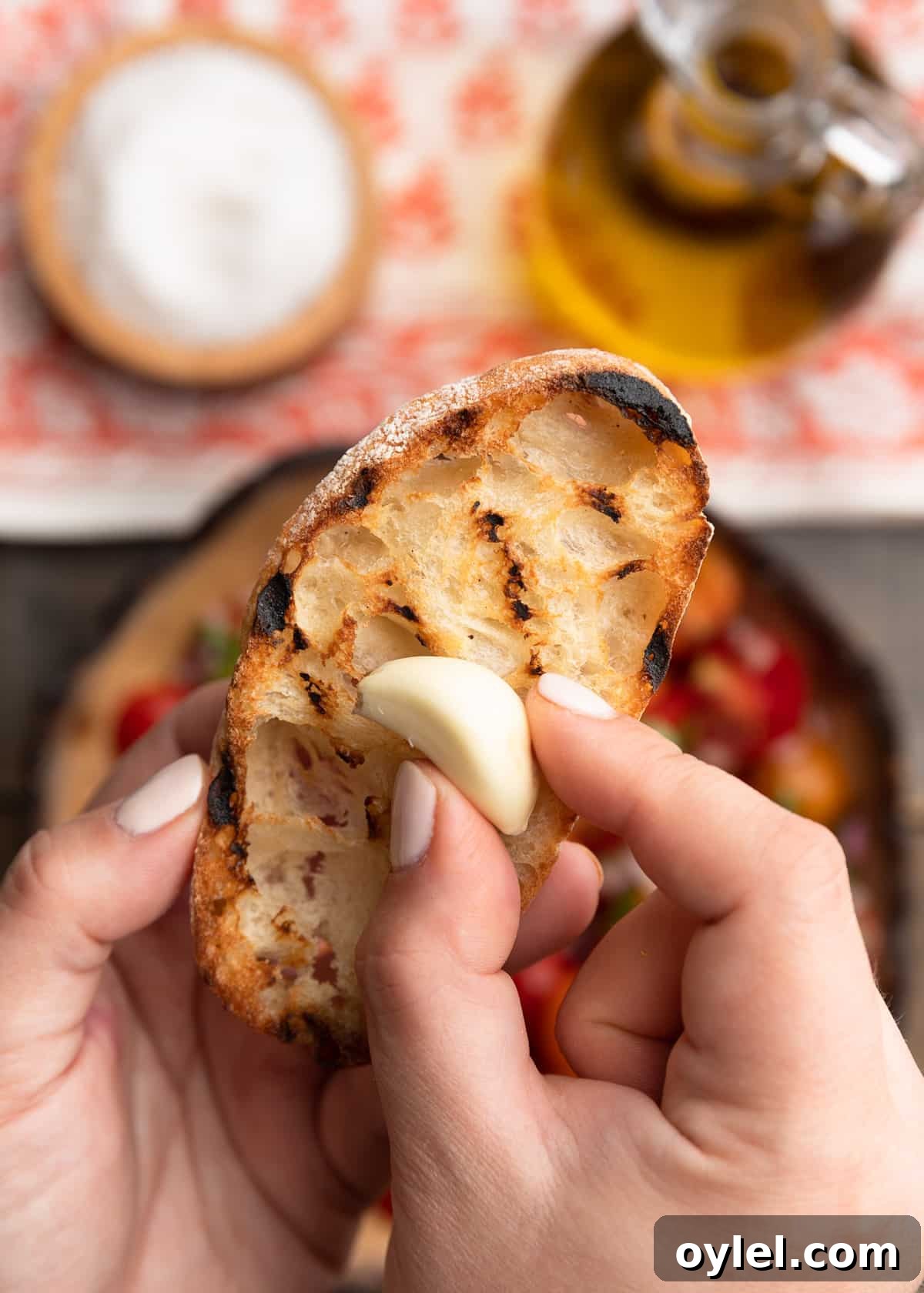 rubbing a raw garlic clove onto a grilled slice of ciabatta