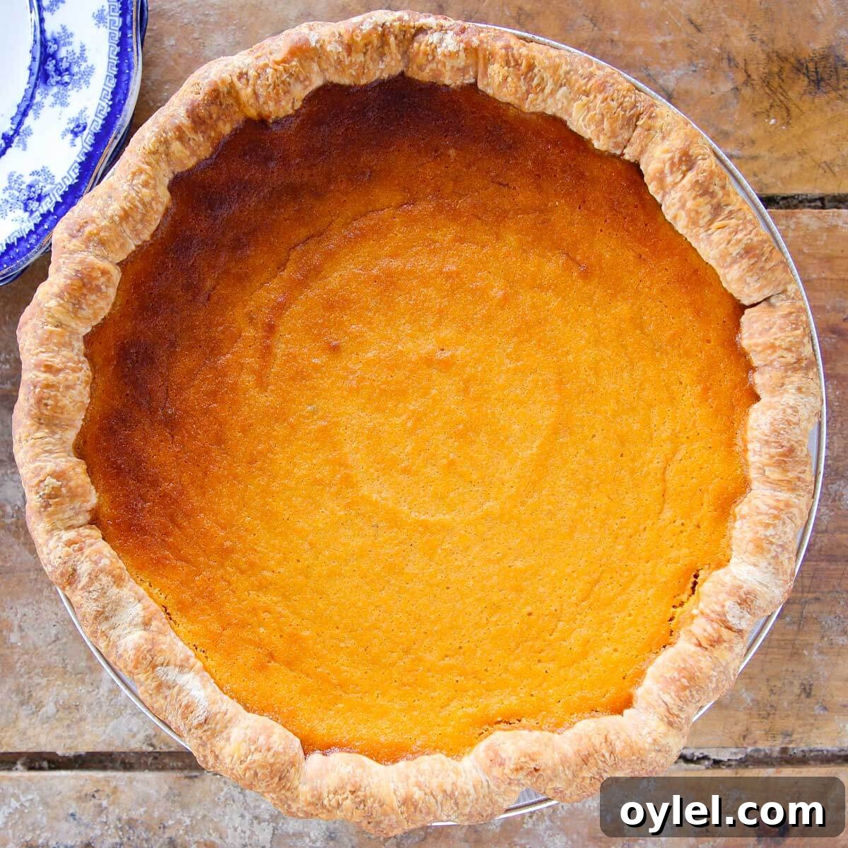Classic Southern Sweet Potato Pie Recipe with Spiced Filling 9 sweet potato pie unsliced on wooden board.
