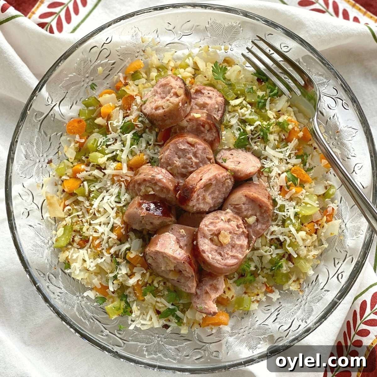 Cauliflower Rice Pilaf topped with sausage in a bowl.