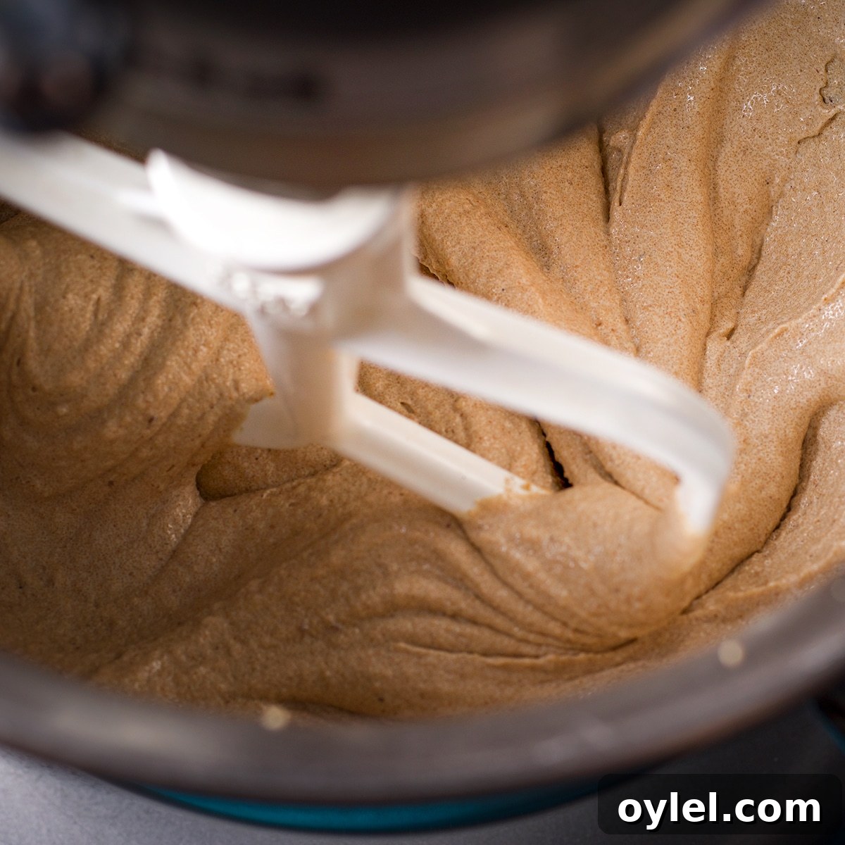 A stand mixer beating butter and sugar.