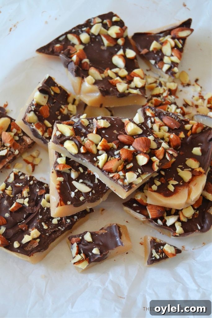 a bunch of almond roca pieces broken up in a pile on a piece of white parchment paper