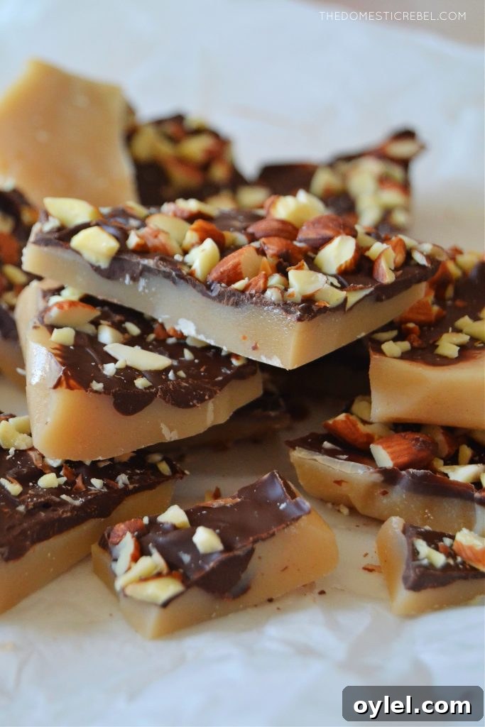 a pile of almond roca toffee on a white piece of parchment paper