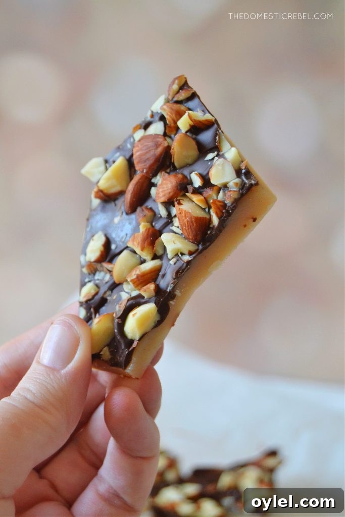 author holding a piece of almond roca toffee 