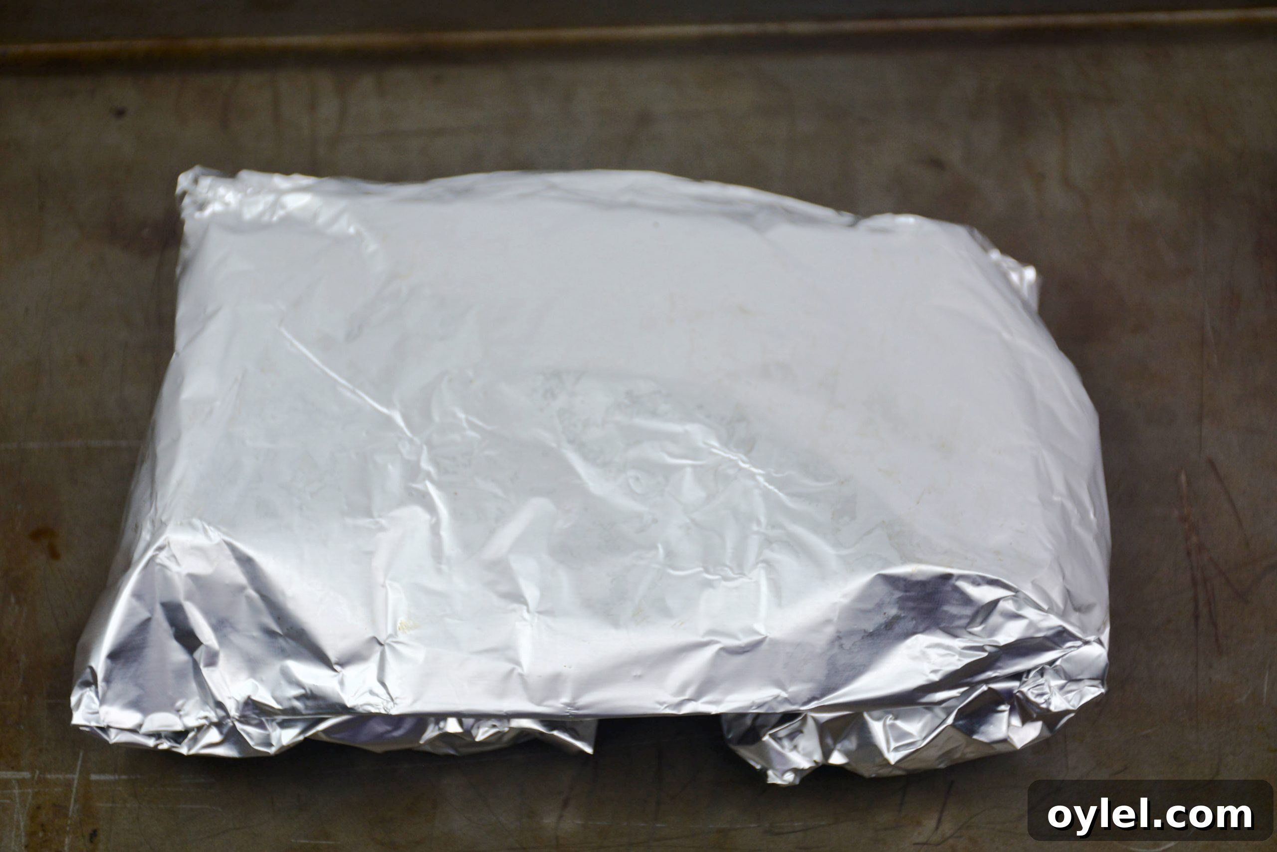 Sealed foil packets on a baking sheet