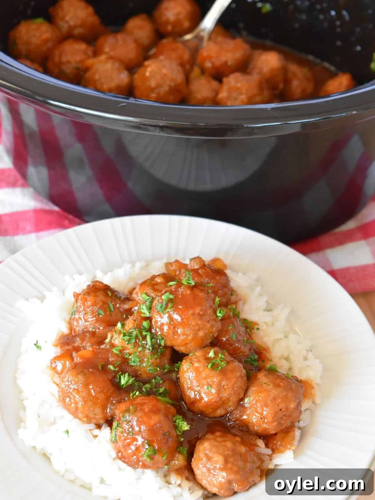 4-Ingredient Slow Cooker Hawaiian Meatballs 2 Slow Cooker Hawaiian Meatballs on a plate of white rice.