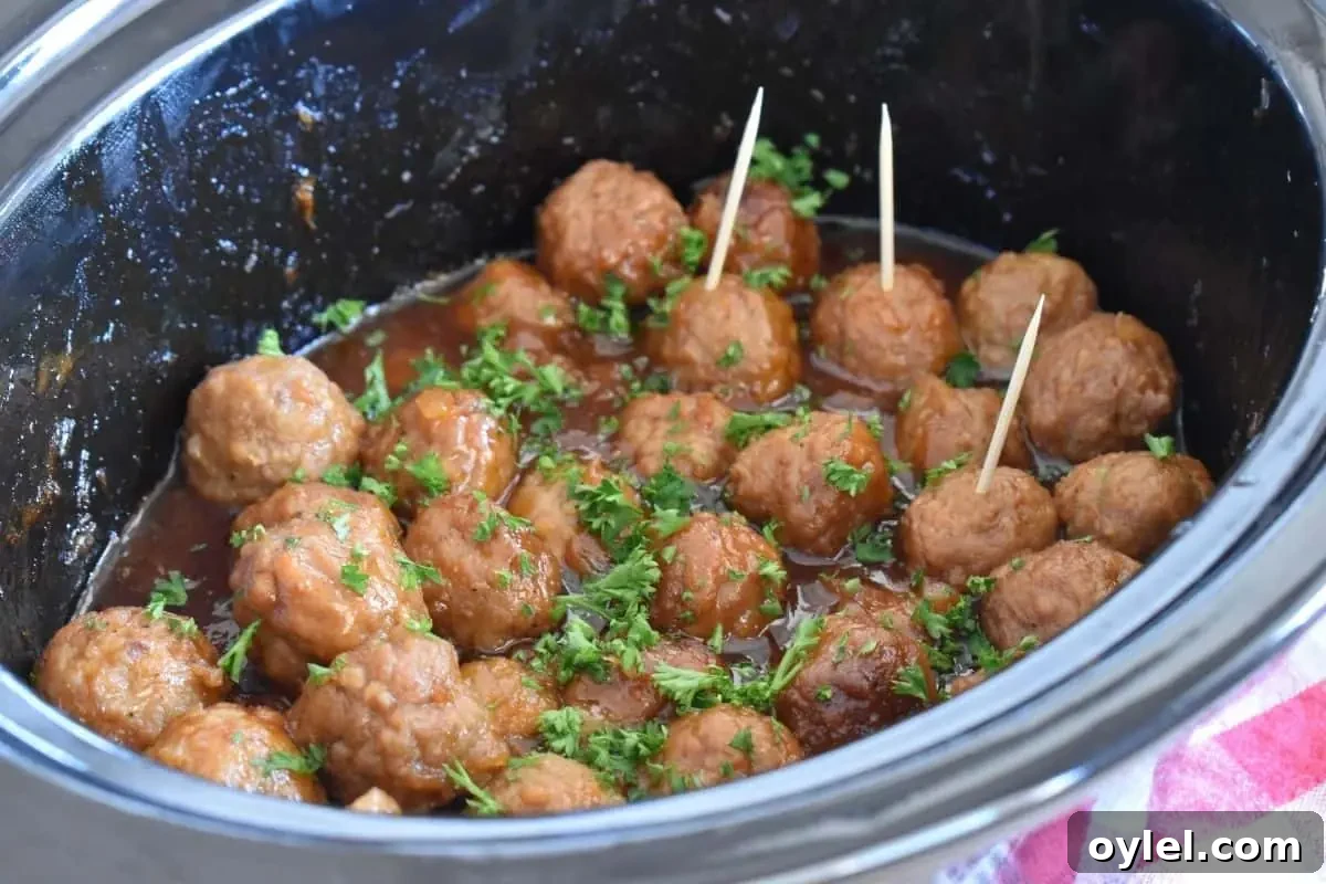 4-Ingredient Slow Cooker Hawaiian Meatballs 3 Slow cooker Hawaiian meatballs in a slow cooker with toothpicks in the meatballs.