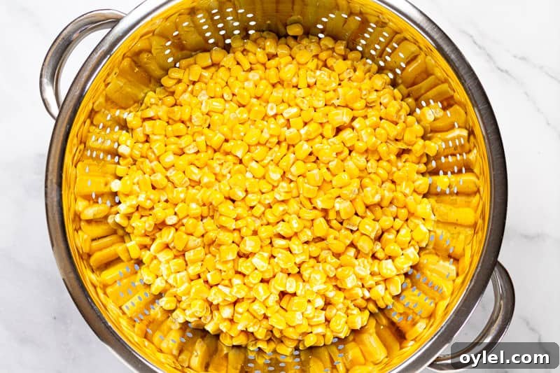 Creamy Elote Soup (Mexican Street Corn) 4 Metal strainer with kernels of sweet corn in it