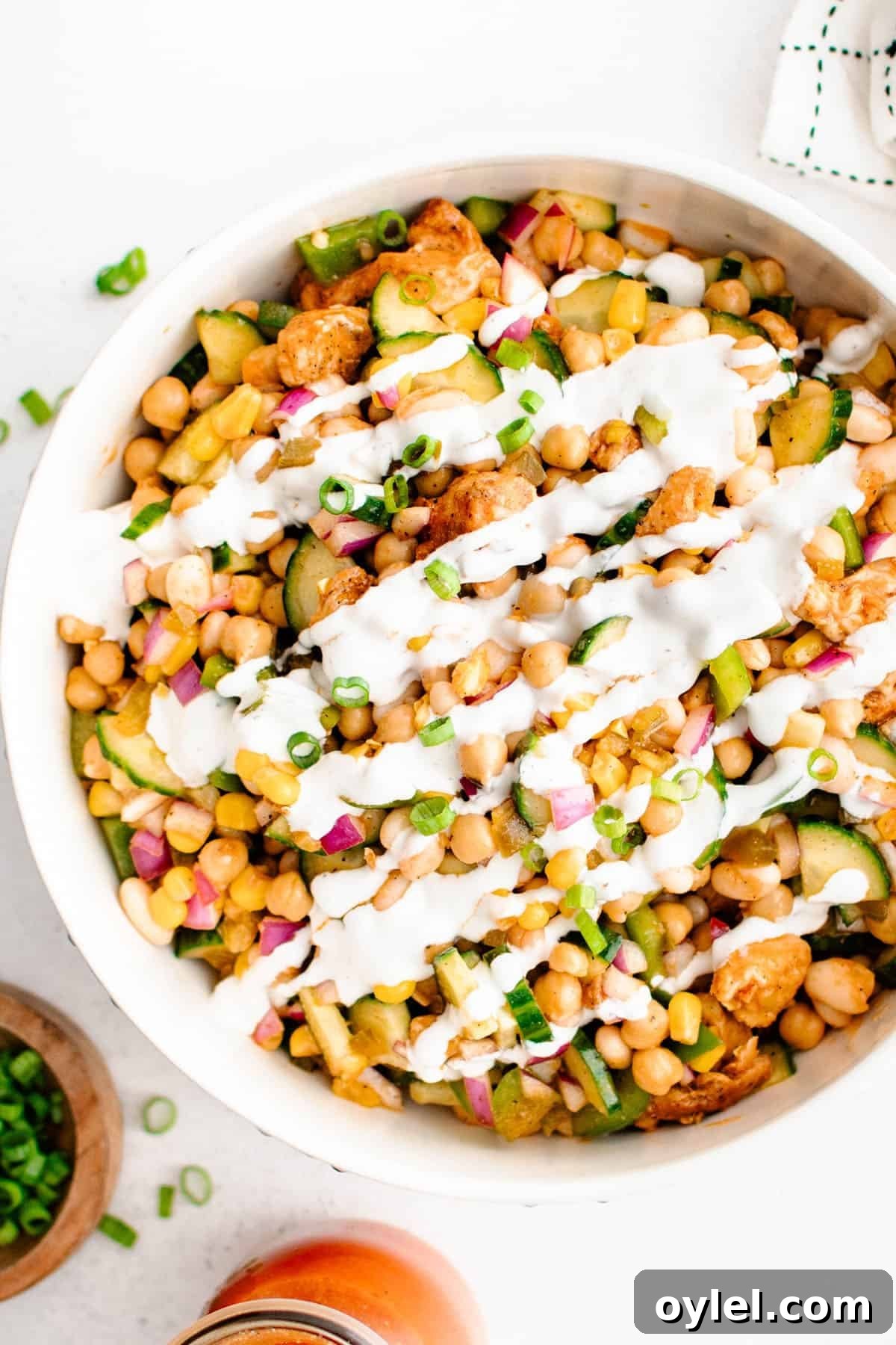 Buffalo Chicken Bean Salad in a serving bowl with ranch dressing drizzled over the top