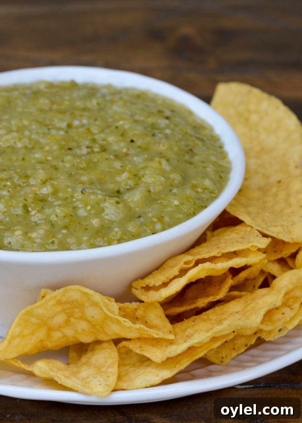 Authentic Roasted Tomatillo Salsa Recipe 2 tomatillo salsa in a bowl with a side of tortilla chips