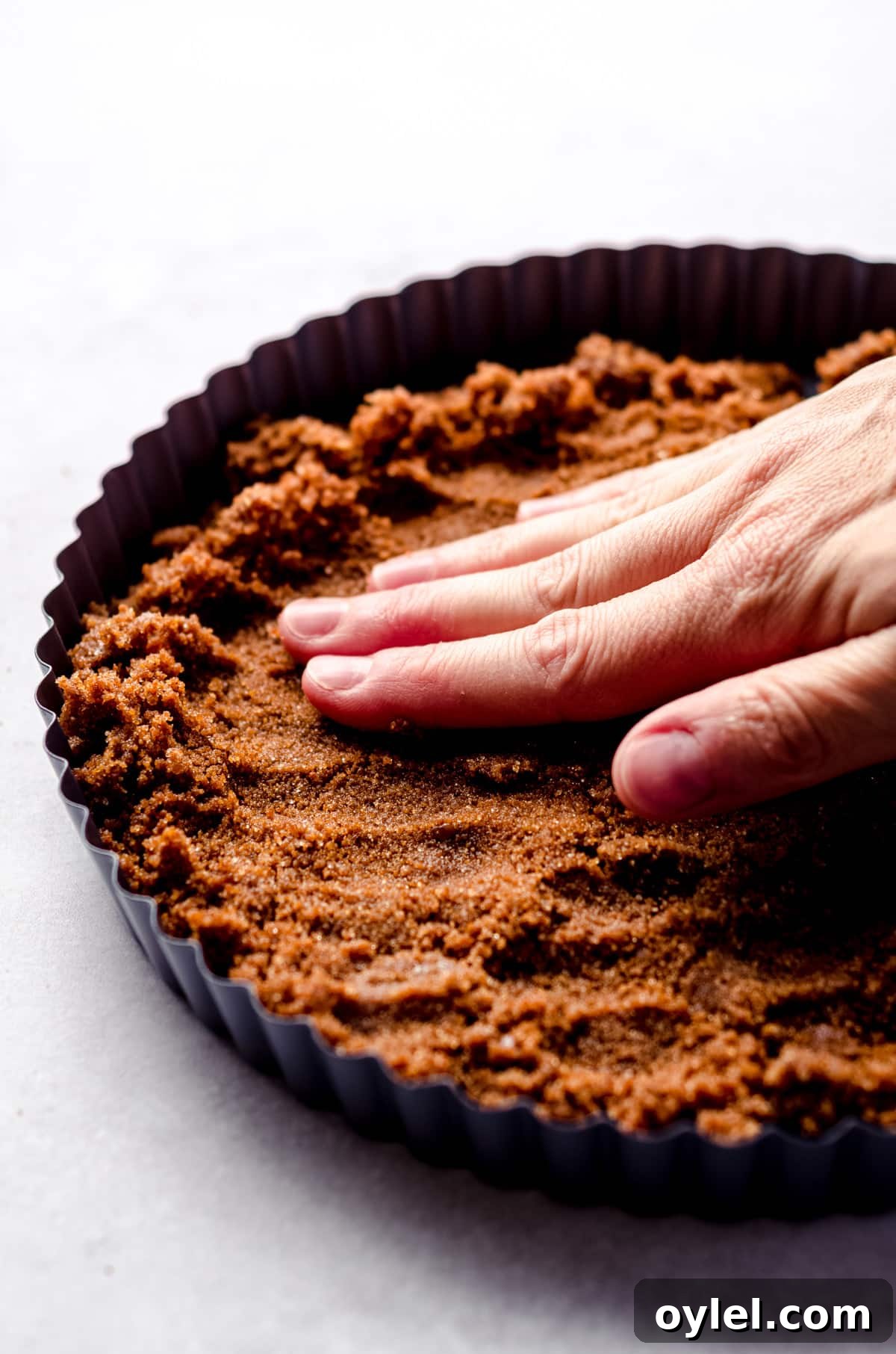 Silky Cranberry Curd Tart Recipe with Buttery Crust 8 Pressing a gingersnap mixture into a tart pan.