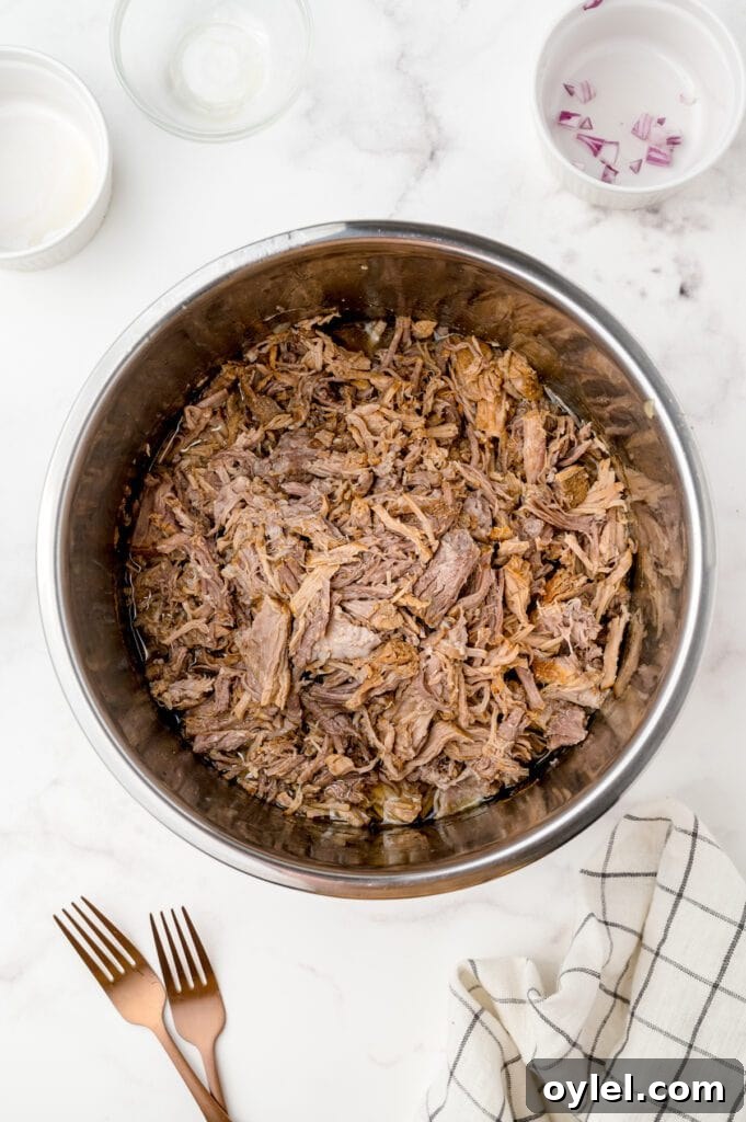 Shredded pulled pork tossed in barbecue sauce inside the Instant Pot for extra flavor.