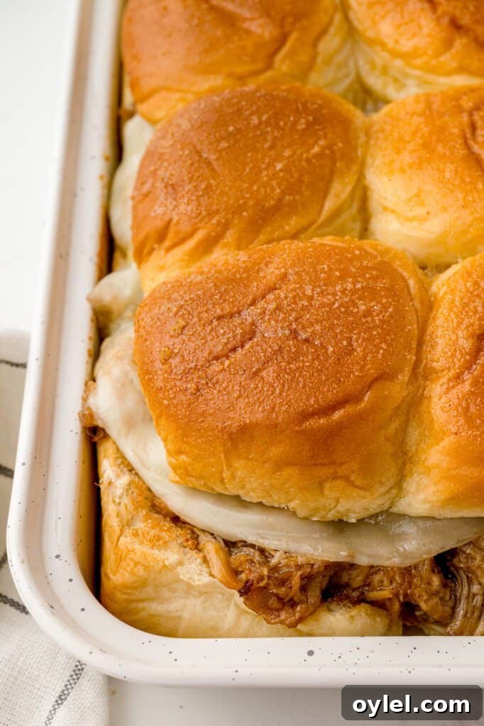 Pulled pork sliders with cheese in a pan.