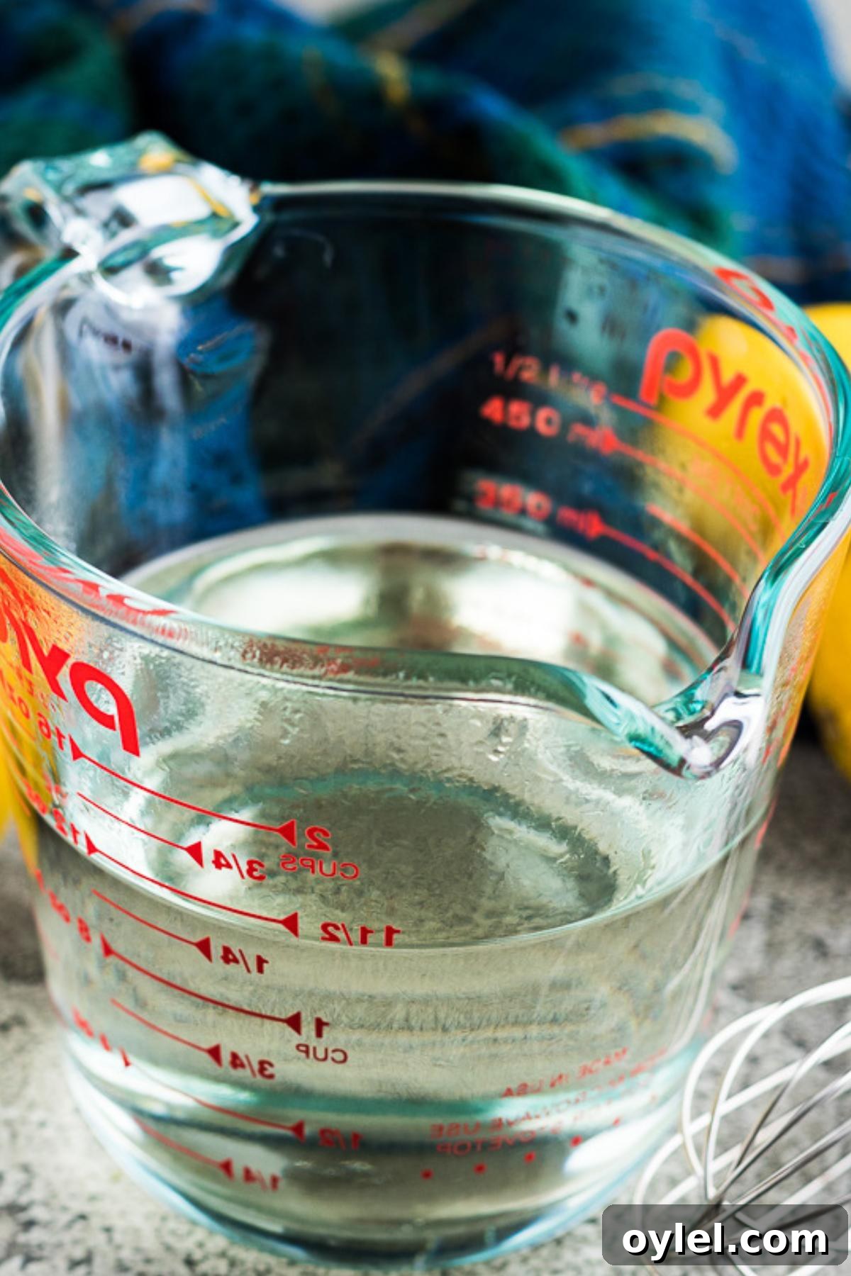 Close up view of simple syrup in a glass measuring cup.