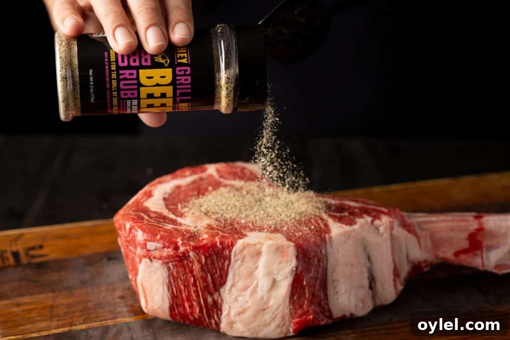 How to Reverse-Sear a Tomahawk Steak for Maximum Flavor 3 Tomahawk steak being seasoned with Hey Grill Hey Beef Rub.