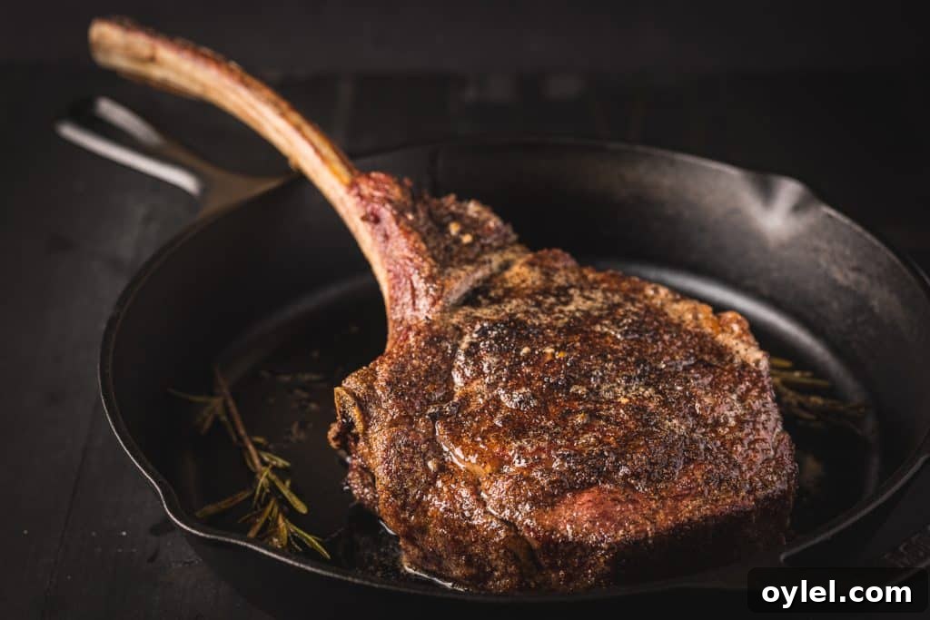 How to Reverse-Sear a Tomahawk Steak for Maximum Flavor 4 Tomahawk steak being seared in a cast iron skillet.