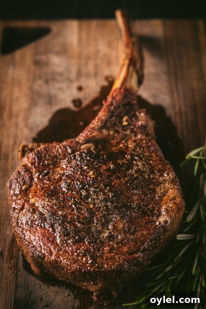 How to Reverse-Sear a Tomahawk Steak for Maximum Flavor 5 Grilled tomahawk steak on a wooden cutting board.