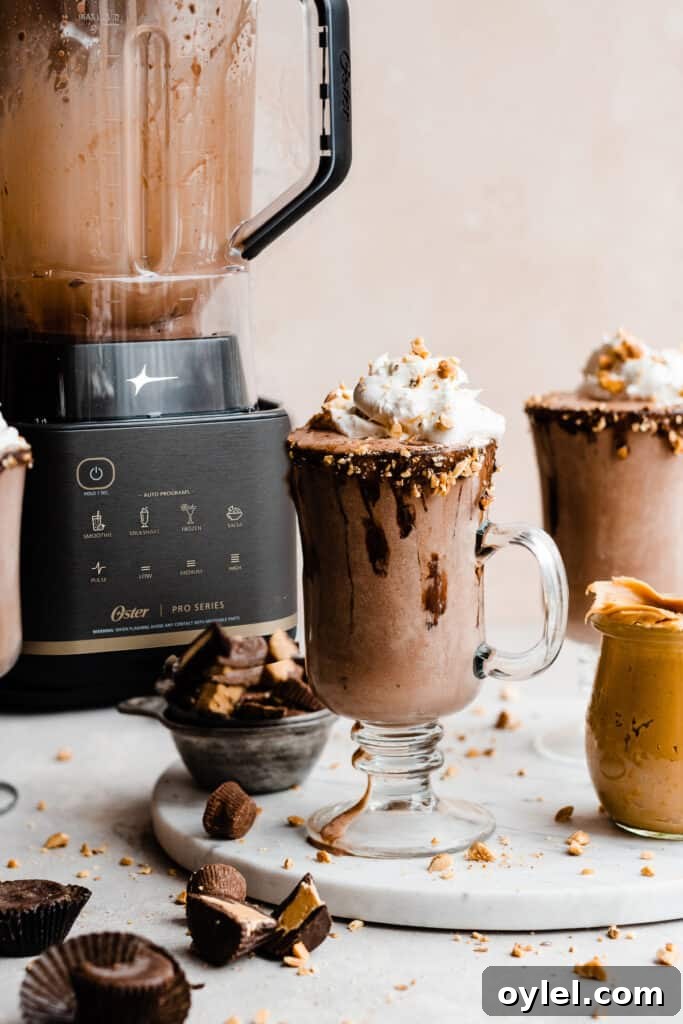Creamy Homemade Peanut Butter Chocolate Milkshake 2 Peanut butter chocolate milkshakes in chocolate dipped glasses on a marble slab.