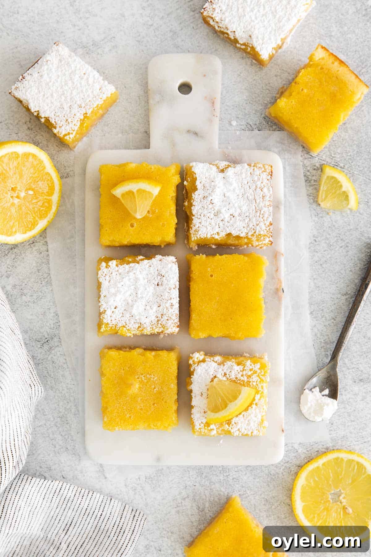 Zesty Gluten-Free Lemon Bars Recipe 8 gluten-free lemon bars with powdered sugar and lemon slices on top.