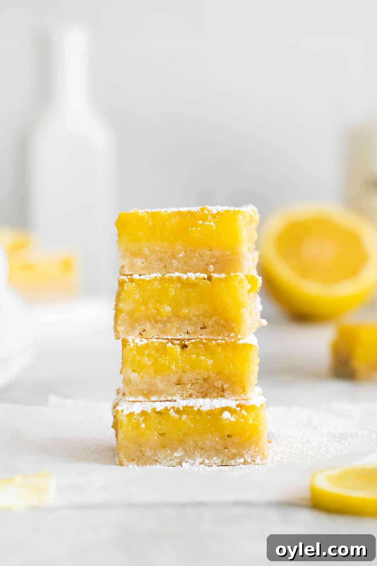 Zesty Gluten-Free Lemon Bars Recipe 9 gluten-free lemon bars stacked on top of each other.
