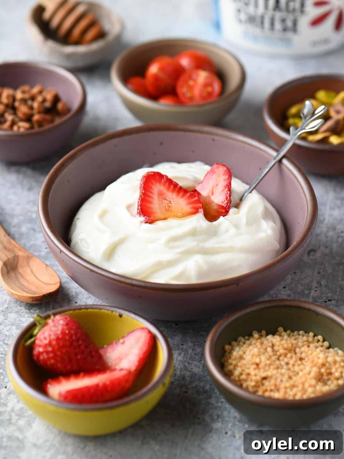 Cottage cheese bowl surrounded by smaller bowls with toppings.