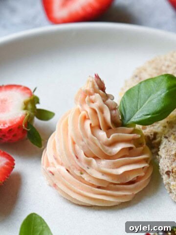 Whipped strawberry butter on a white plate with basil in it.