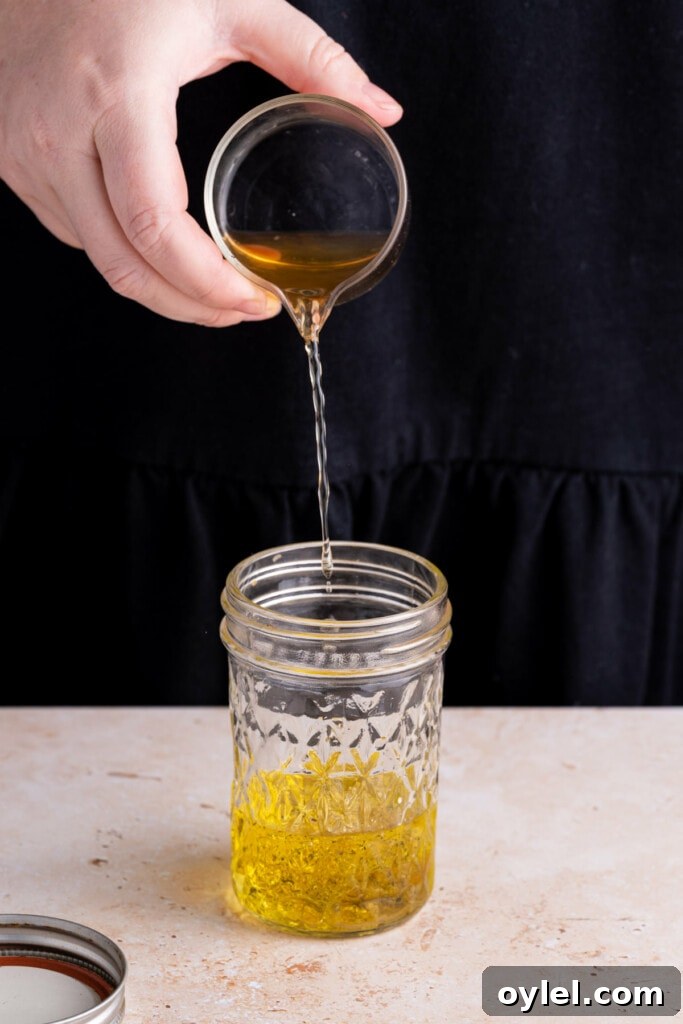 Mixing up Honey Dijon Vinaigrette in a glass jar.
