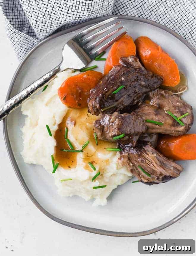 Juicy Instant Pot Beef Roast with Garlic and Herbs 3 Image of tender pot roast, carrots, mashed potatoes, and gravy.