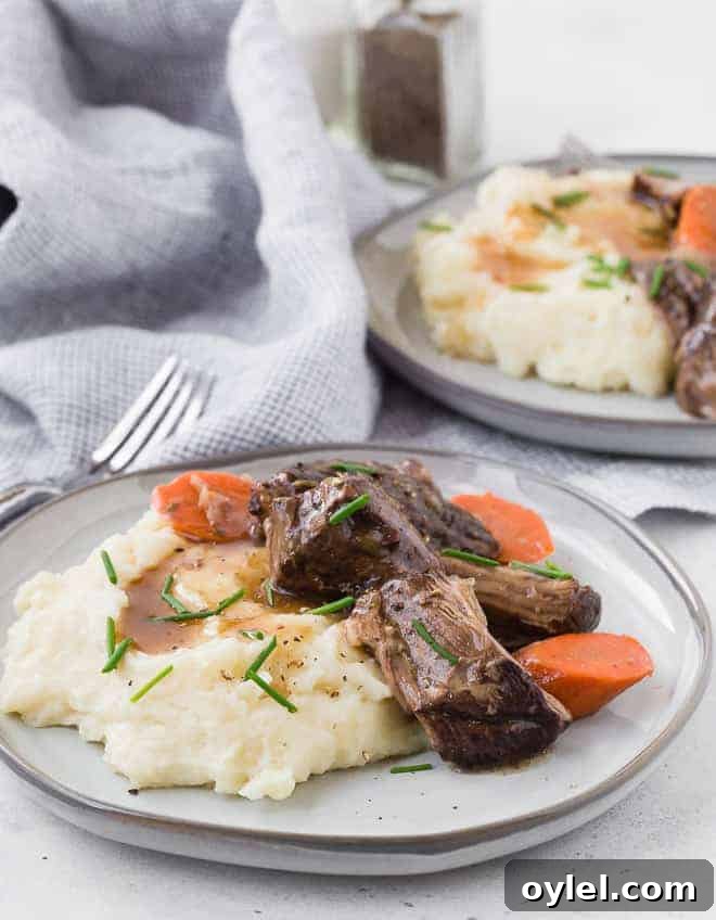 Juicy Instant Pot Beef Roast with Garlic and Herbs 4 Image of two plates of tender beef roast with mashed potatoes and gravy.