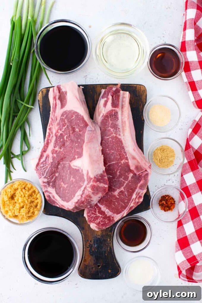 Asian steak marinade ingredients arrange in bowls around a cutting board with two ribeye steaks.