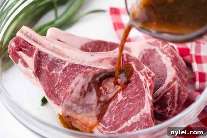 Pouring Asian style steak marinade over two ribeye steaks in a bowl.