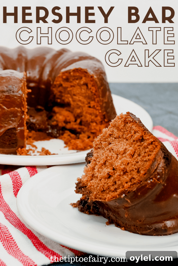 A close up slice of Hershey Bar Chocolate Cake on a white saucer with the cut cake behind it.