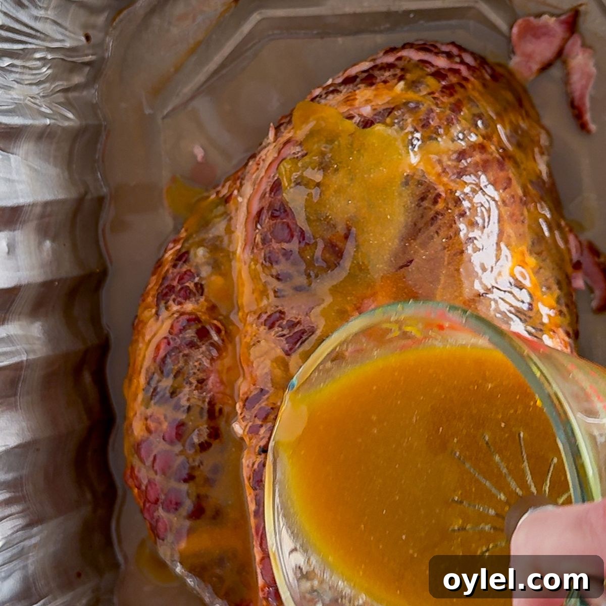 Pouring the seasoned sauce on the ham.