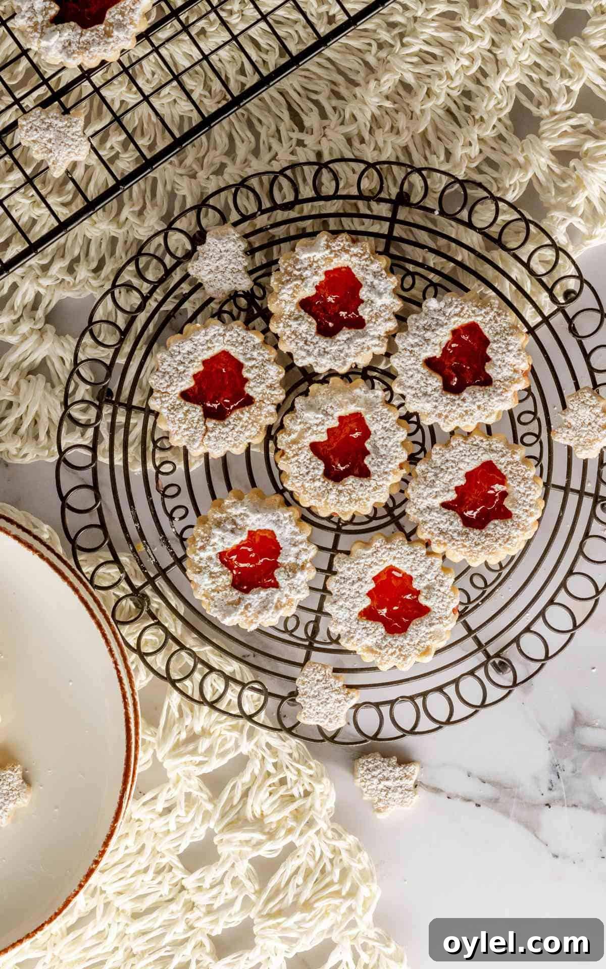 Overhead of linzer tarts with Christmas tree shaped centers.