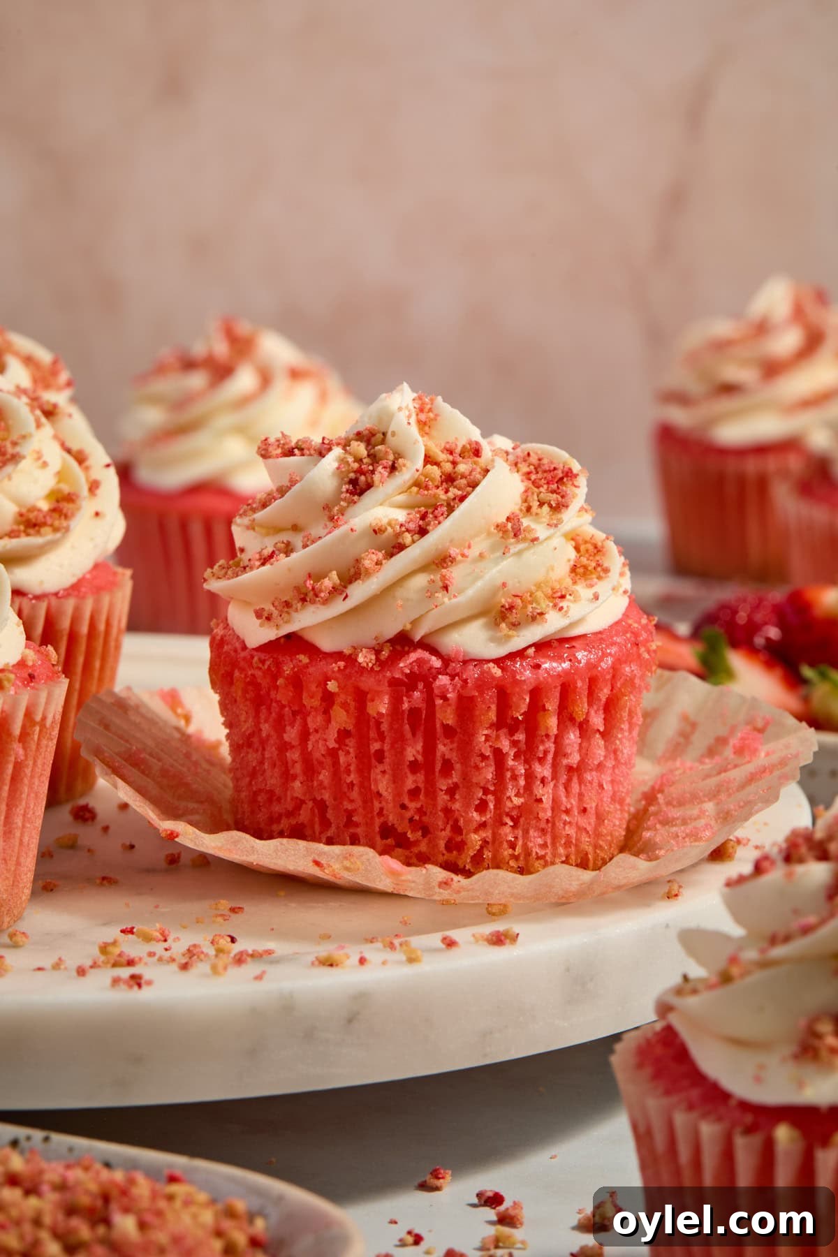 Strawberry Crunch Cupcakes Recipe with Crumble Topping 13 Cupcakes arranged on tray with liner pulled down to show texture.