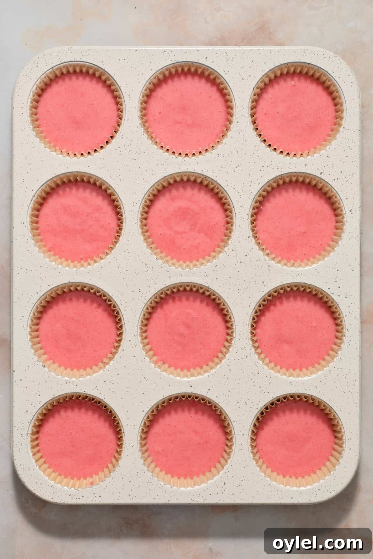 Strawberry Crunch Cupcakes Recipe with Crumble Topping 6 Cupcake liners filled with strawberry cupcake batter before baking.