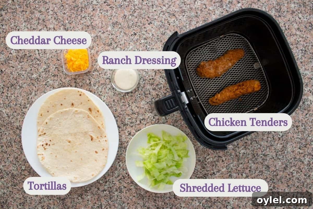 Ingredients for a wrap: cheddar cheese, ranch dressing, chicken tenders in an air fryer, flour tortillas on a plate, and a bowl of shredded lettuce, all labeled and arranged on a granite countertop.
