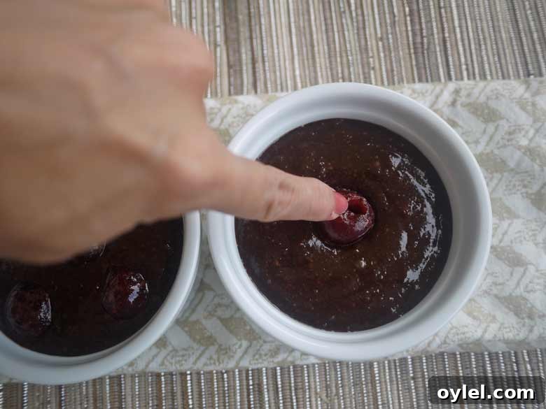 Cherries being added to ramekins.
