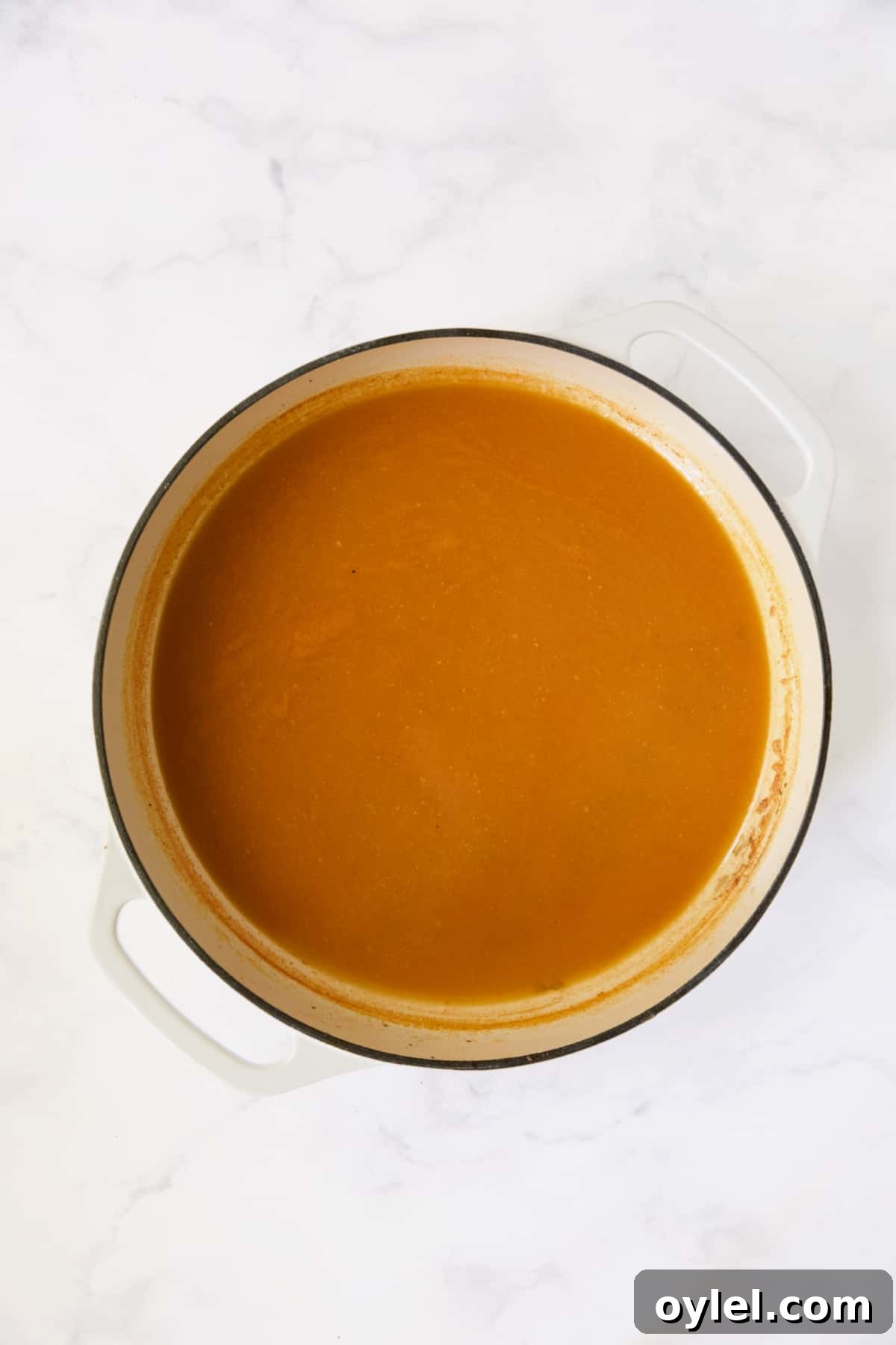 Sauce for cabbage in white enamel cast iron skillet after being reduced.