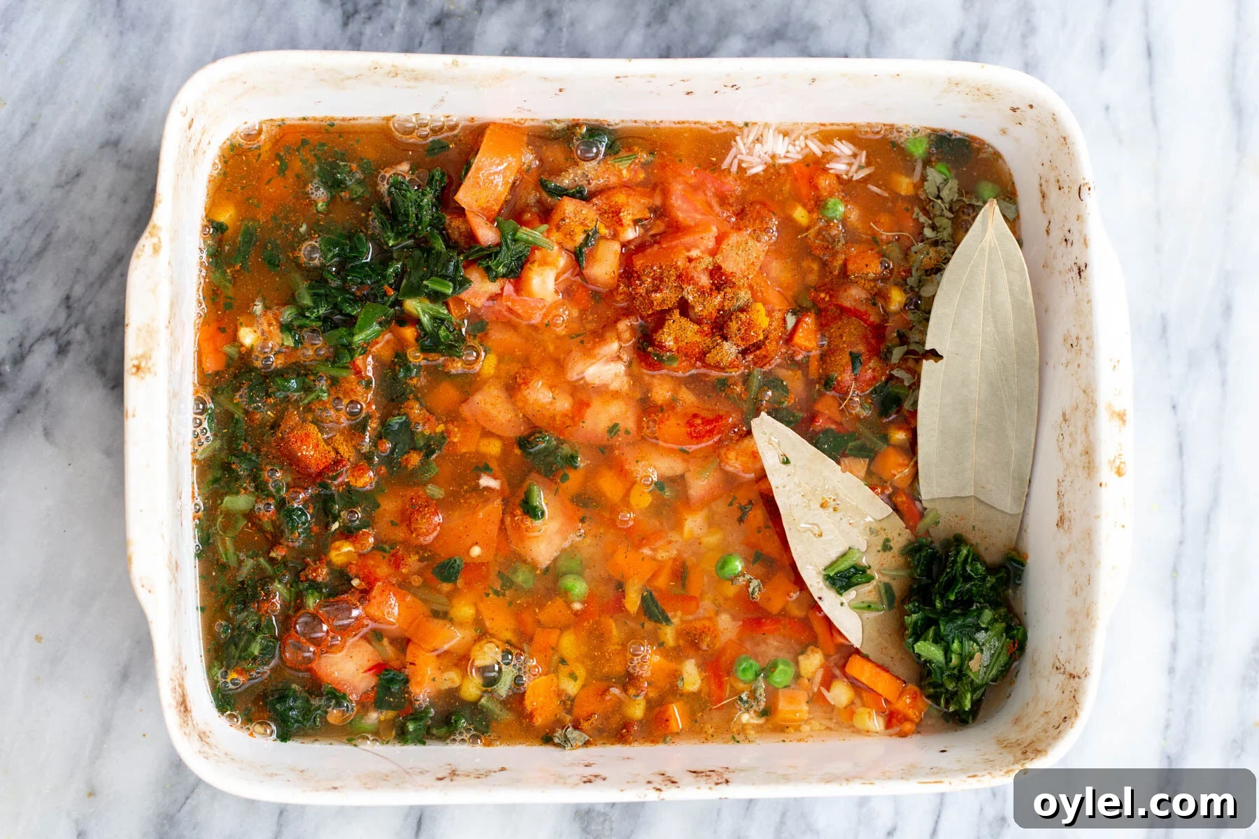 rice and vegetables cooking in a casserole dish 