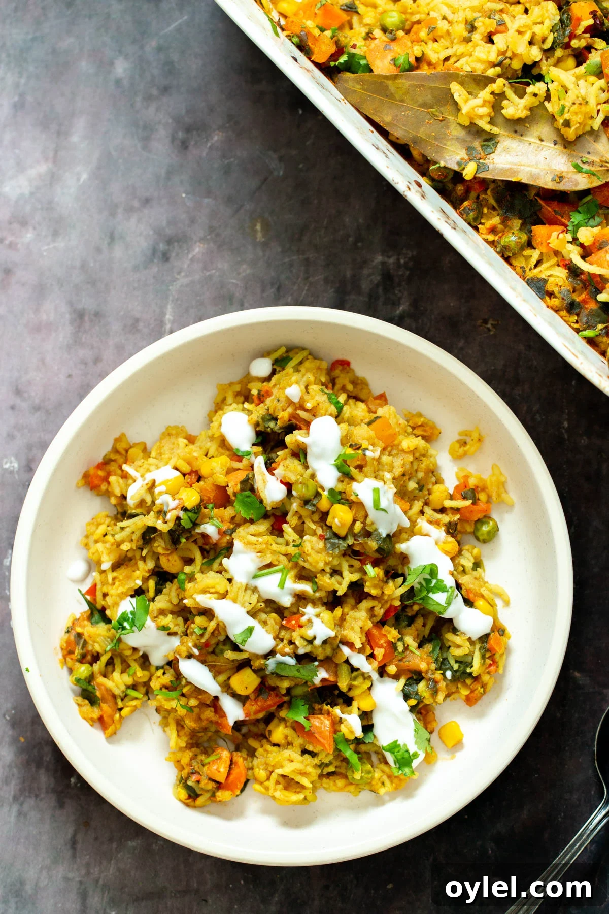 a plate with vegan lentil rice casserole served drizzled with yogurt 