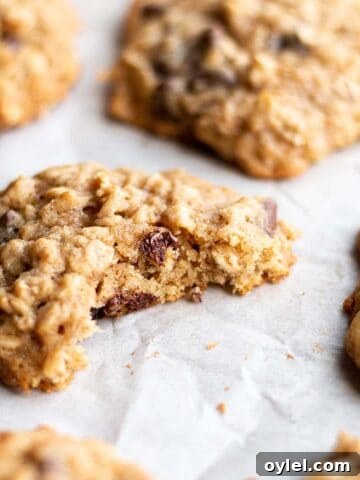 Oatmeal cookie with a bite taken out on a baking sheet