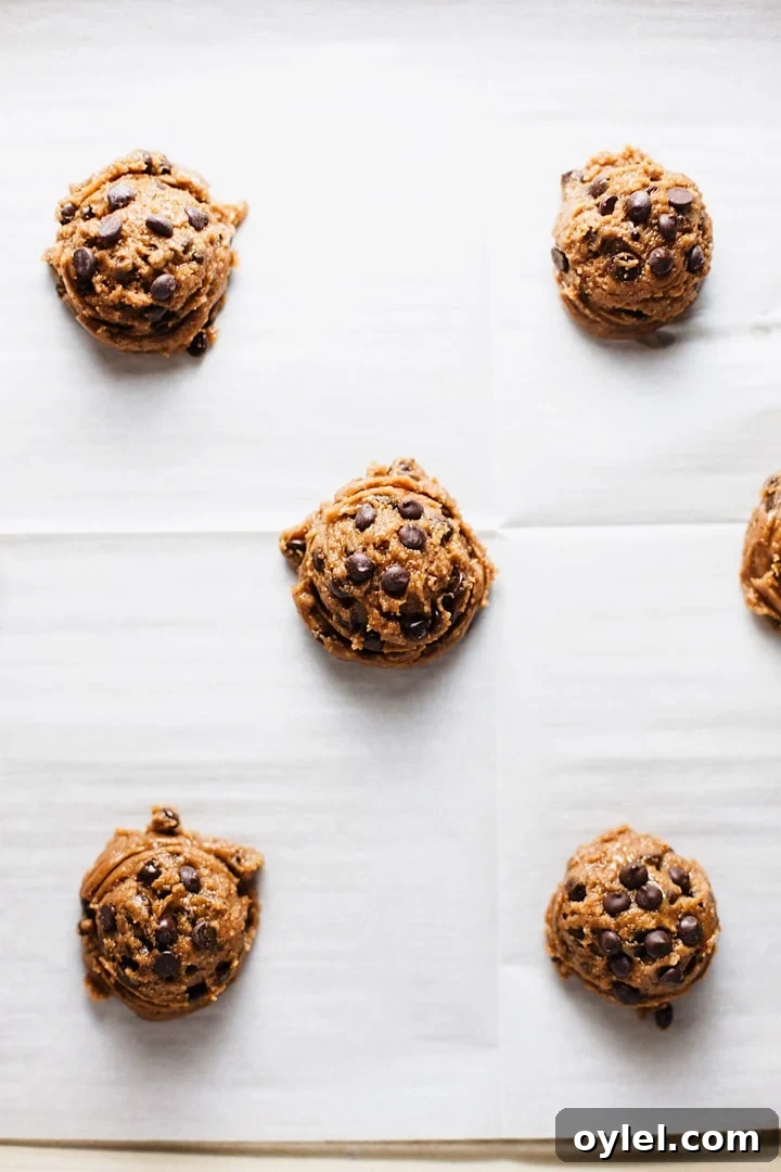 Flourless Chocolate Chip Cookies That Stay Chewy 8 Cookie dough scoops on parchment paper.