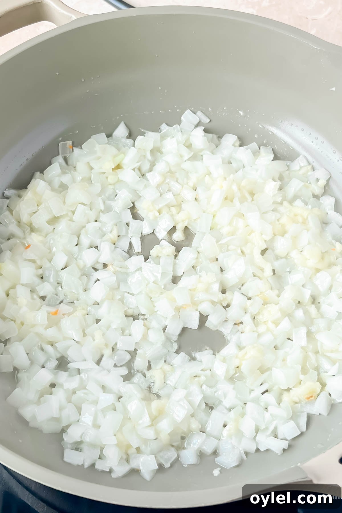 onions sautéed in in gray pan.