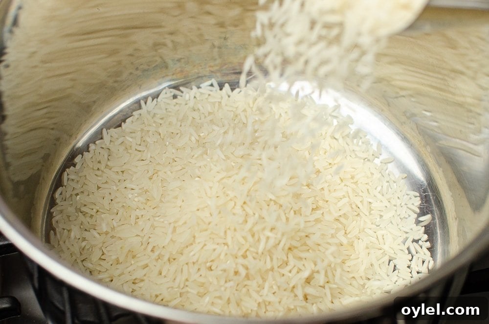 Authentic Jasmine Sticky Rice Recipe from Thailand 9 Jasmine rice being poured into a silver cooking pot